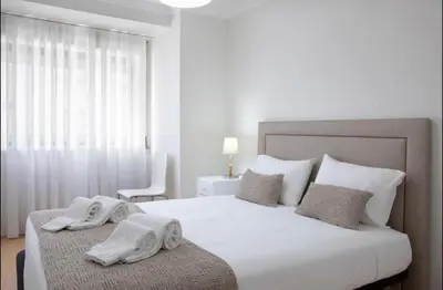 a bedroom with a large white bed with towels on it at Belas Artes Apartment by LovelyStay in Porto