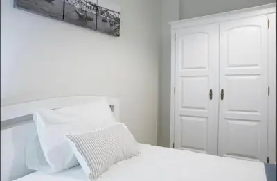 a white bedroom with a bed with white pillows at Belas Artes Apartment by LovelyStay in Porto