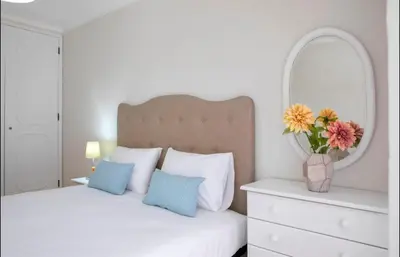 a bedroom with a bed with a mirror and a vase of flowers at Belas Artes Apartment by LovelyStay in Porto