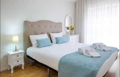 a bedroom with a large white bed with blue pillows at Belas Artes Apartment by LovelyStay in Porto