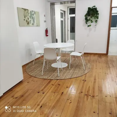 a table and chairs in a room with a wooden floor at PORTO GARDEN YARD APARTMENT in Porto