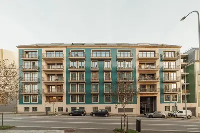 a green building with cars parked in front of it at OPORTO GUEST Renovato Luxus Flat w/ parking in Porto