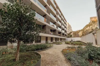 a courtyard of an apartment building with a tree at OPORTO GUEST Renovato Luxus Flat w/ parking in Porto