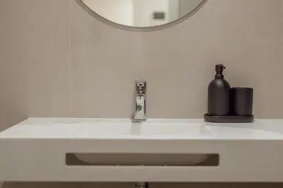 a bathroom sink with a soap dispenser and a mirror at OPORTO GUEST Renovato Luxus Flat w/ parking in Porto