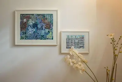 two framed pictures on a wall with flowers in a vase at Touchy Porto in Porto