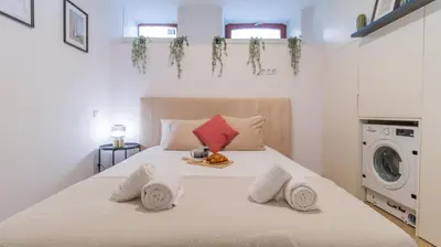 a bedroom with a bed with a washing machine at Old Town 1BR Duplex by LovelyStay in Porto