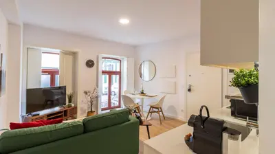 a living room with a green couch and a table at Old Town 1BR Duplex by LovelyStay in Porto