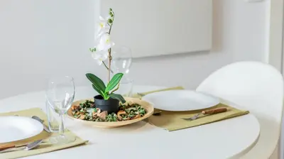 a table with white plates and a plant in a bowl at Old Town 1BR Duplex by LovelyStay in Porto
