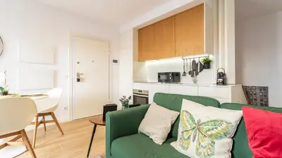 a living room with a green couch and a kitchen at Old Town 1BR Duplex by LovelyStay in Porto