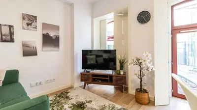 a living room with a tv and a green couch at Old Town 1BR Duplex by LovelyStay in Porto