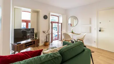 a living room with a green couch and a table at Old Town 1BR Duplex by LovelyStay in Porto