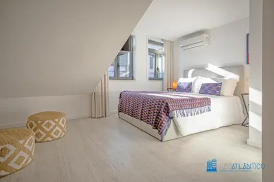 a white bedroom with a bed and a staircase at Porto Formosa Central Lofts in Porto