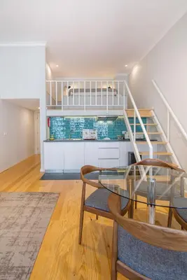 a dining room with a glass table and stairs at Almada 151 Porto in Porto