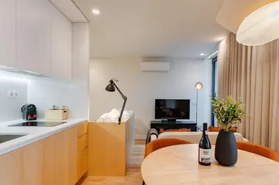 a kitchen and a living room with a table at Feel Porto Corporate Housing Boavista in Porto