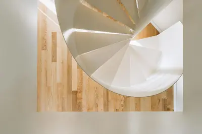 a circular staircase in a room with a wooden floor at Feel Porto Corporate Housing Boavista in Porto