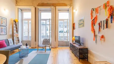 a living room with a couch and a tv at Eccentric Mouzinho Mezzanine by LovelyStay in Porto