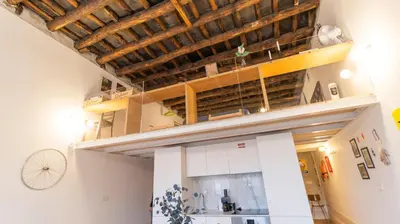 a kitchen with white cabinets and a wooden ceiling at Eccentric Mouzinho Mezzanine by LovelyStay in Porto