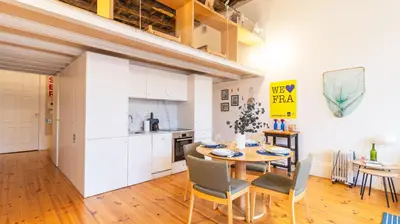 a kitchen and dining room with a table and chairs at Eccentric Mouzinho Mezzanine by LovelyStay in Porto