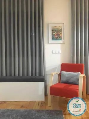 a living room with a red chair and a window at Studio Jardim São Lázaro in Porto