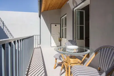a patio with a glass table and chairs on a balcony at 157 Flores Apartment in Porto