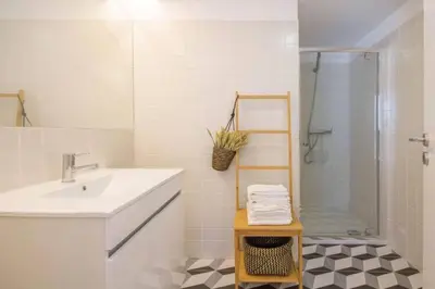 a white bathroom with a sink and a shower at 157 Flores Apartment in Porto