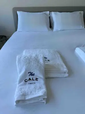 a white bed with two towels on it at The Cale - Porto, Sá da Bandeira in Porto