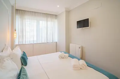 a bedroom with a bed with blue pillows and a window at Feel Porto Downtown Apartments & Studios in Porto