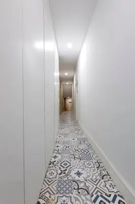 a corridor with a tile floor in a hallway at Oporto Cosy Apartment in Porto