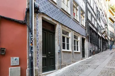 an alley with a green door on a building at Oporto Lovely Apartment in Porto