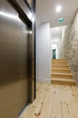 a hallway with a wooden floor and a staircase at Oporto Lovely Apartment in Porto