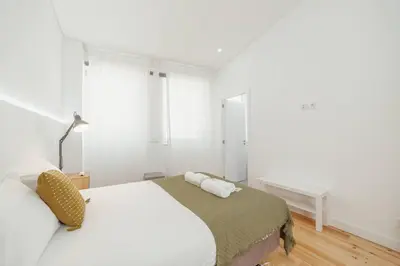 a white bedroom with a bed and a window at Modern Villa by Hosty in Porto