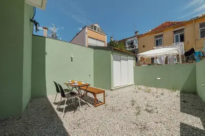 a small patio with a table and chairs next to a building at Modern Villa by Hosty in Porto