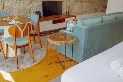 a living room with a blue couch and a table at Constituição Deluxe by Hosty in Porto