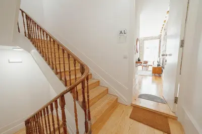 a staircase in a home with white walls and wooden floors at Constituição Deluxe by Hosty in Porto
