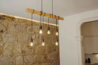 aendant light with lights hanging from a stone wall at Constituição Deluxe by Hosty in Porto
