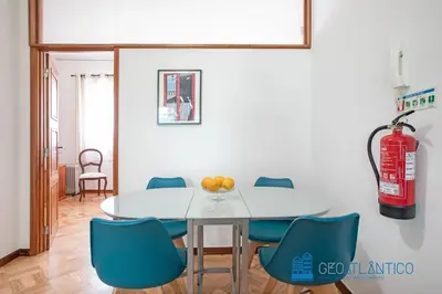a dining room with a white table and blue chairs at Porto Sé Classic Terrace Apartment in Porto