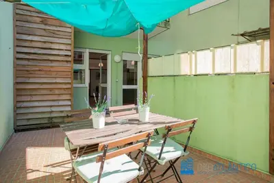 a wooden table with two chairs and an umbrella at Porto Sé Classic Terrace Apartment in Porto