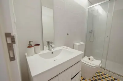 a white bathroom with a sink and a toilet at Cozy Almada by Hosty in Porto