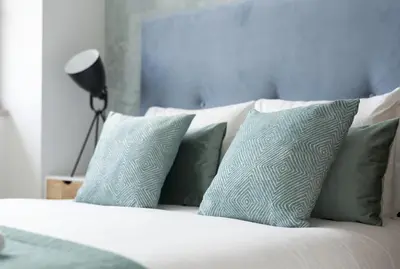 a bed with blue and white pillows on it at Santo Ildefonso RicaHouses in Porto