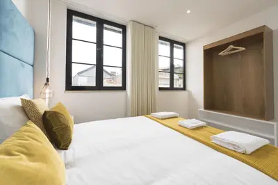 a bedroom with a large white bed with windows at Santo Ildefonso RicaHouses in Porto