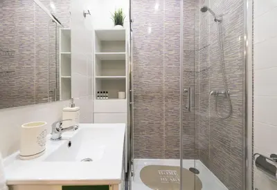 a bathroom with a sink and a glass shower at Santo Ildefonso RicaHouses in Porto