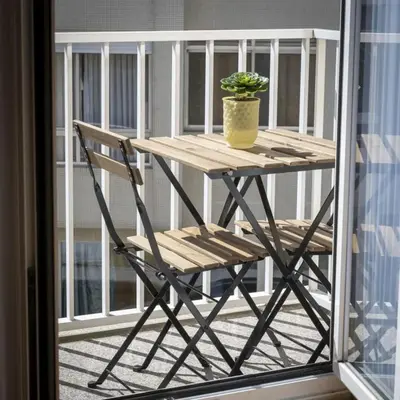 a wooden table and a chair on a balcony at Modern Living - Santa Catarina in Porto