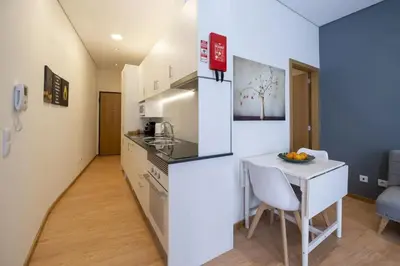a kitchen and dining room with a table and a small kitchen at Modern Living - Santa Catarina in Porto