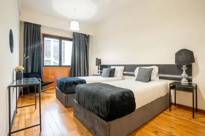 a bedroom with two beds and a large window at Sublime Downtown Retreat by ELSA, 180m2 in Porto