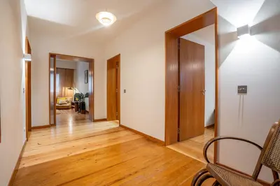 an empty living room with wooden floors and an open door at Sublime Downtown Retreat by ELSA, 180m2 in Porto