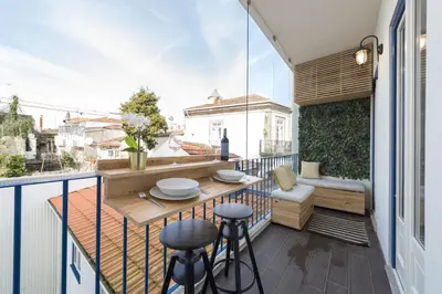 a balcony with a table and stools on a balcony at S. Bento Downtown Apt in Porto