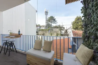 a balcony with a white railing and a table and chairs at S. Bento Downtown Apt in Porto