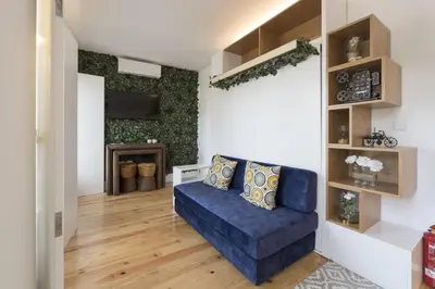 a living room with a blue couch and a tv at S. Bento Downtown Apt in Porto