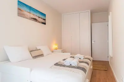 a bedroom with a white bed with towels on it at Morro Garden Apartment by Hosty in Vila Nova de Gaia