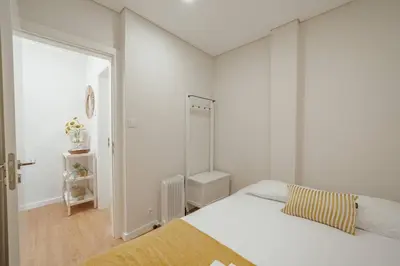 a white bedroom with a bed and a mirror at Morro Garden Apartment by Hosty in Vila Nova de Gaia